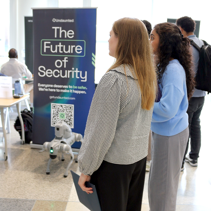two women standing in front of an exhibit booth