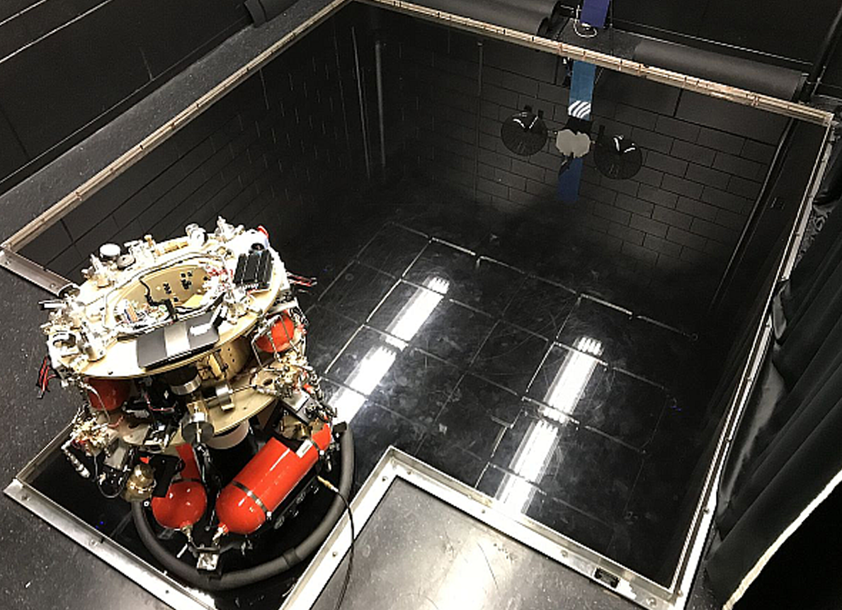 cilindrical robot with tanks near the bottom static on a reflective floor